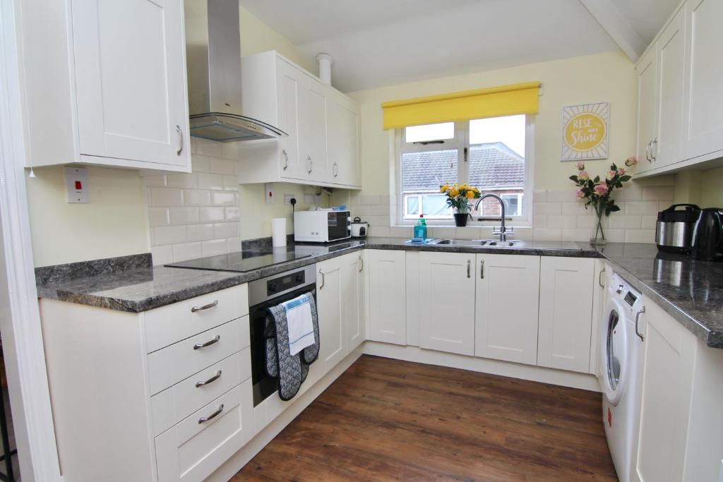 a kitchen with white cabinets and a sink at Avenue Place in Leamington Spa