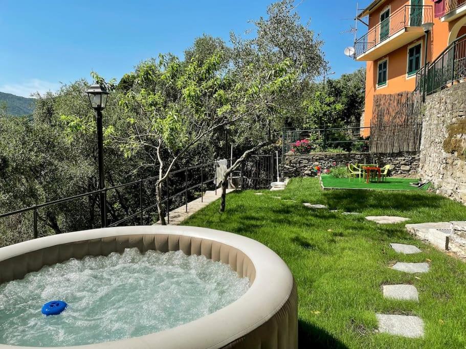 una vasca idromassaggio in un cortile accanto a una casa di [The Olive Trees]- jacuzzi-garden-wifi-barbecue-parking a Ageno
