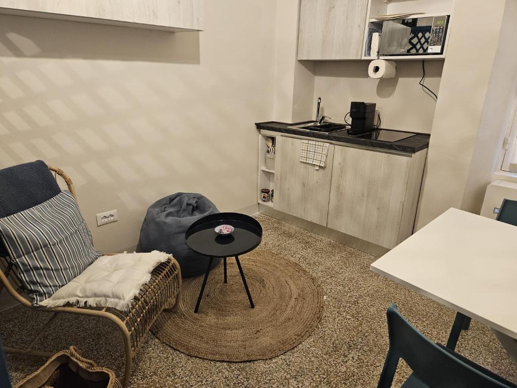 un piccolo soggiorno con un tavolo e una cucina di CASA MENOTTI a Sanremo