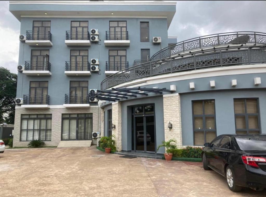 a blue building with a car parked in front of it at swiss pearl continental hotel in Kano