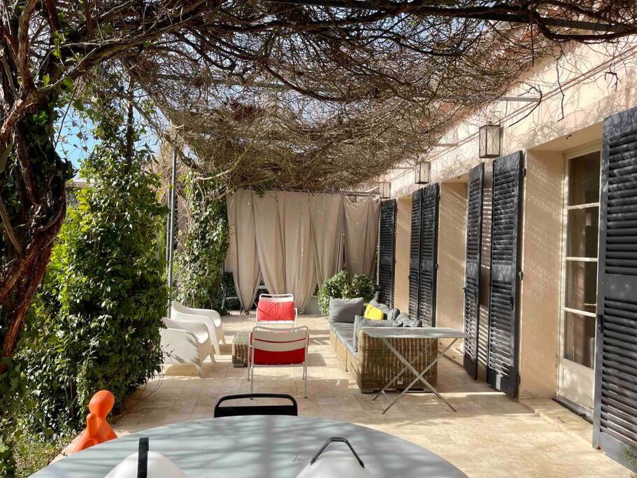 d'une terrasse avec une table, des chaises et une table. dans l'établissement Villa de charme + Loft à 5 min du centre d'Aix, à Aix-en-Provence