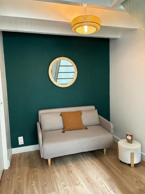 - un canapé dans une pièce dotée d'un mur vert dans l'établissement Maisonnette plein centre 2p, à Libourne