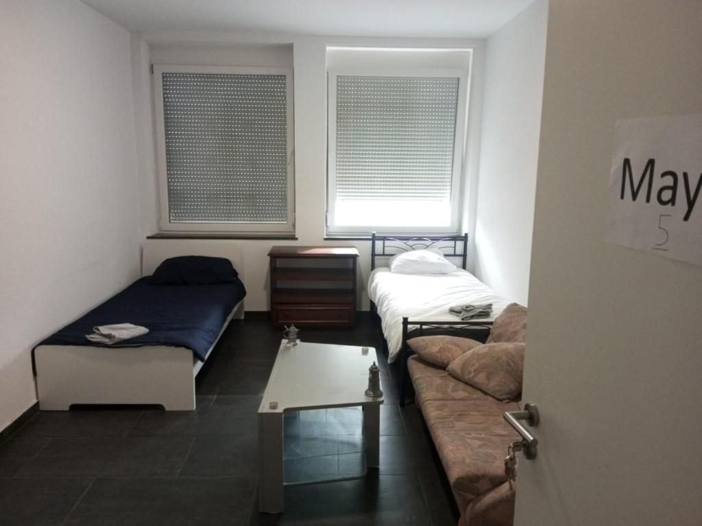 a room with a couch and a bed and windows at Maya Zimmer in Heilbronn Zentrum in Heilbronn