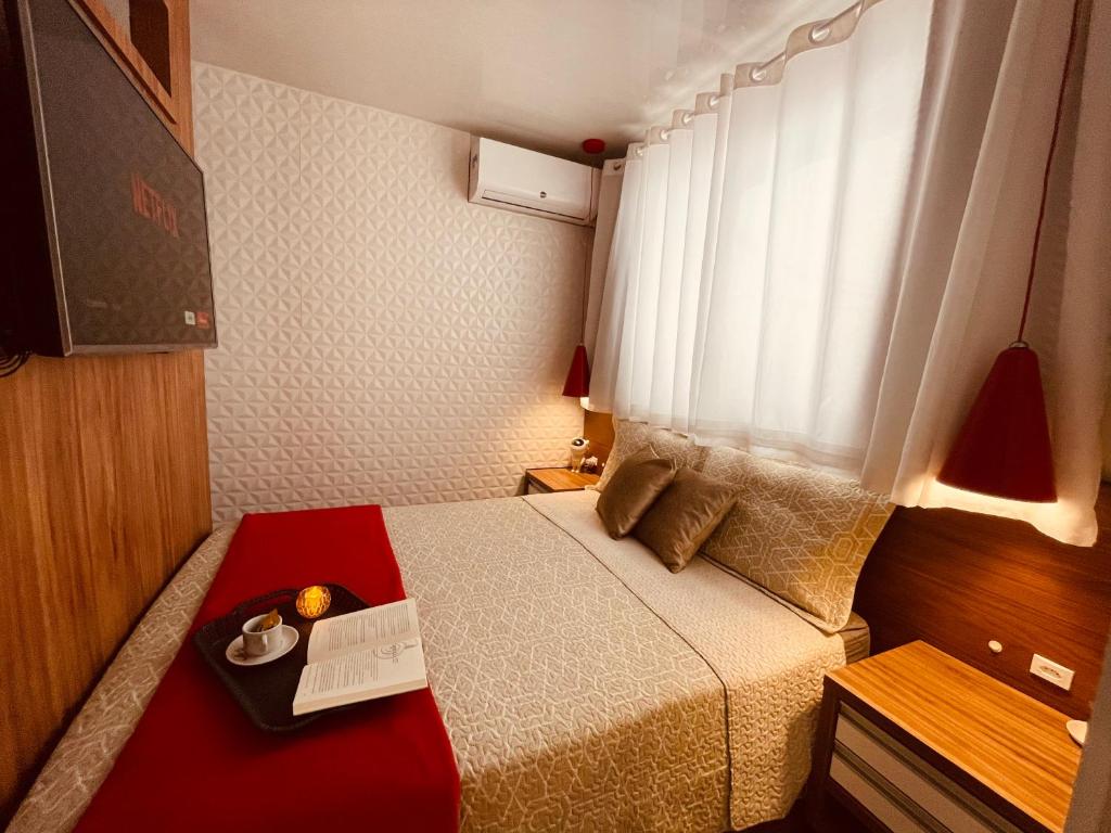 mały pokój z łóżkiem i oknem w obiekcie Loft encantador C - 8 km de Floripa w mieście São José