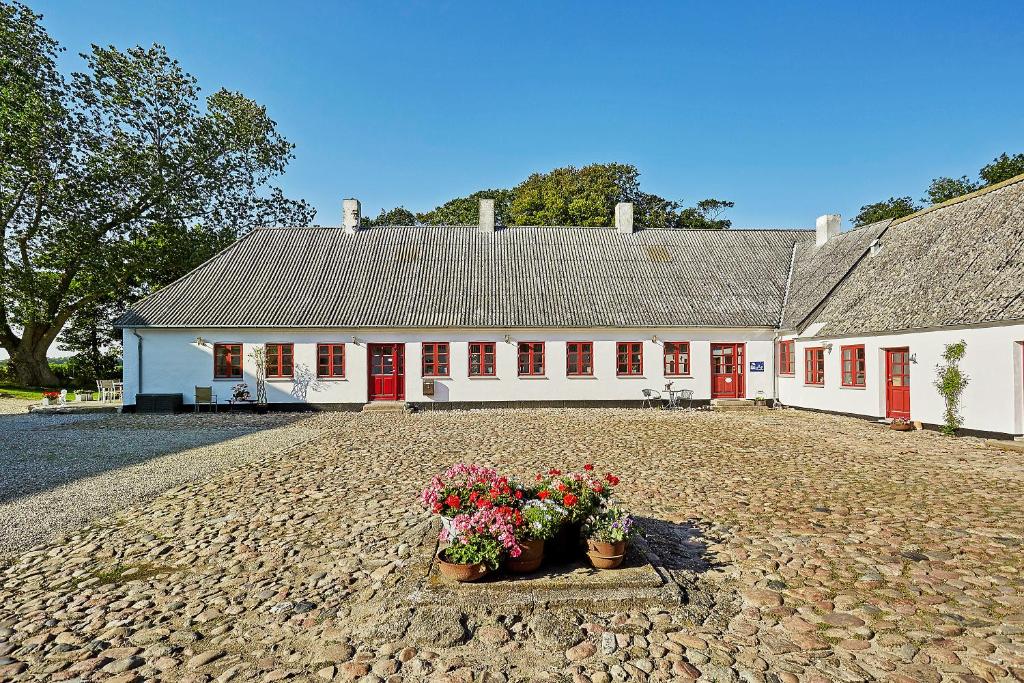 un edificio bianco con porte rosse e due piante in vaso di Bed and Breakfast Åløkke a Nyborg