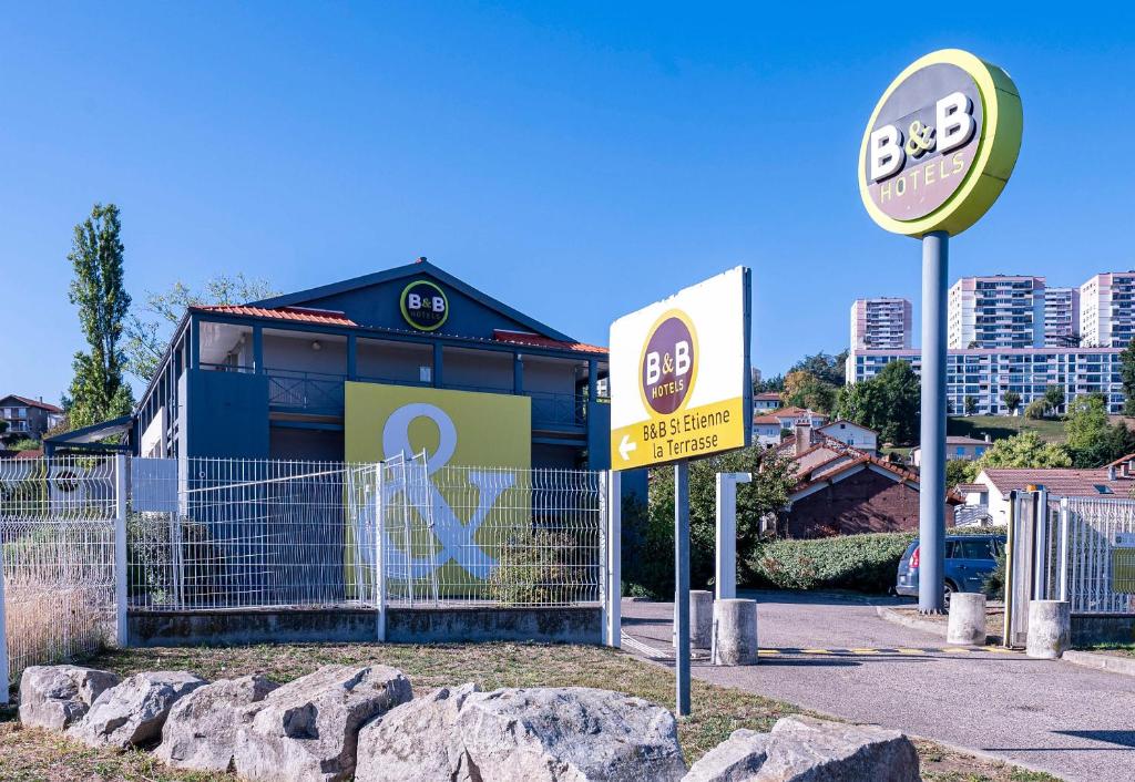 un edificio con una señal delante de él en B&B HOTEL Saint-Etienne La Terrasse en Villars