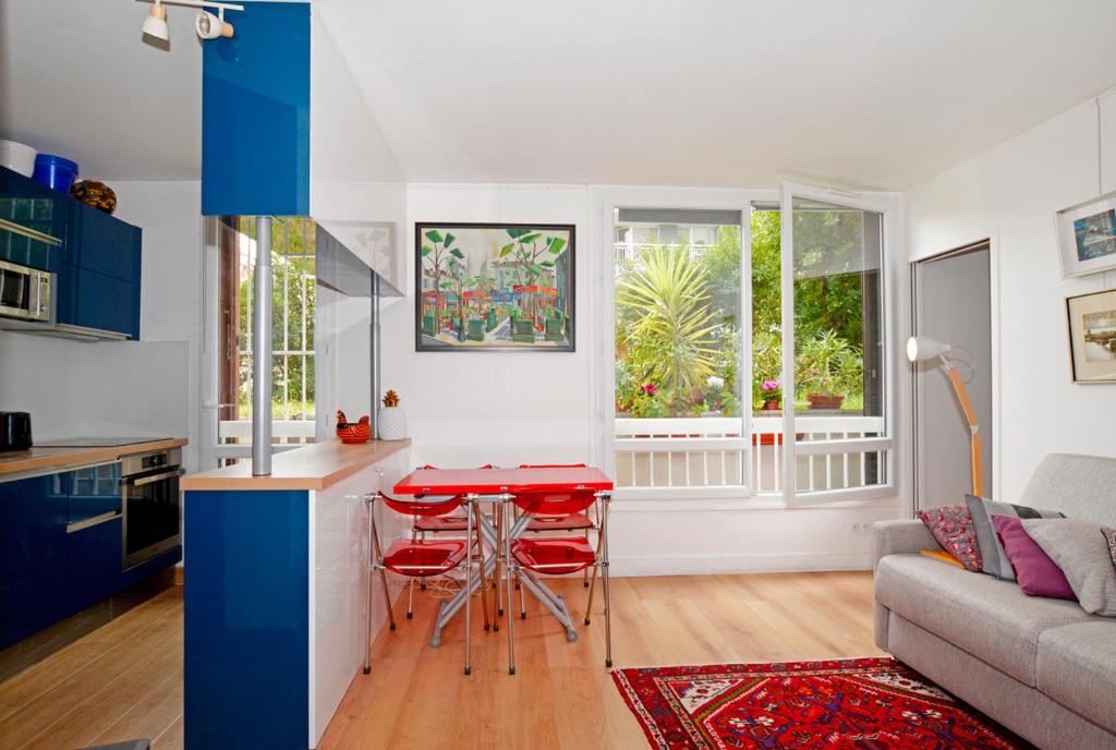 Il comprend une cuisine et un salon avec une table rouge. dans l'établissement Beaux 2 pièces Daumesnil, à Paris