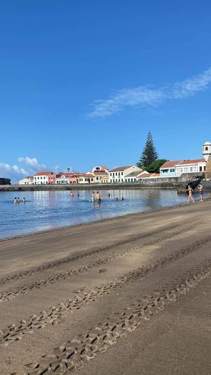 a group of people in the water at a beach at Wavecrest in Horta