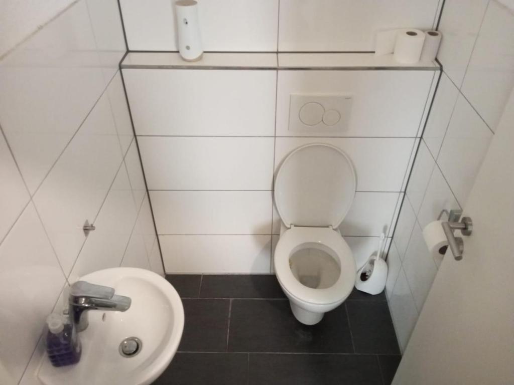 a small bathroom with a toilet and a sink at Anna Zimmer im UG Neu und Modern in Heilbronn