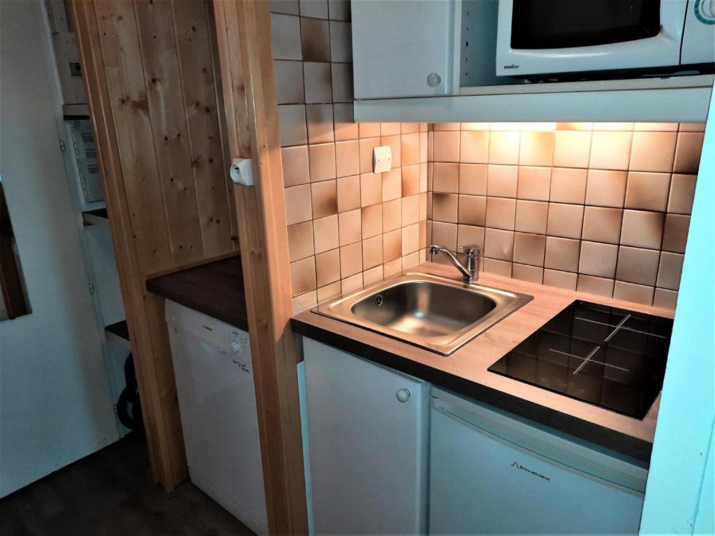 a small kitchen with a sink and a microwave at Résidence Chaviere - Studio pour 2 Personnes 034 in Les Menuires