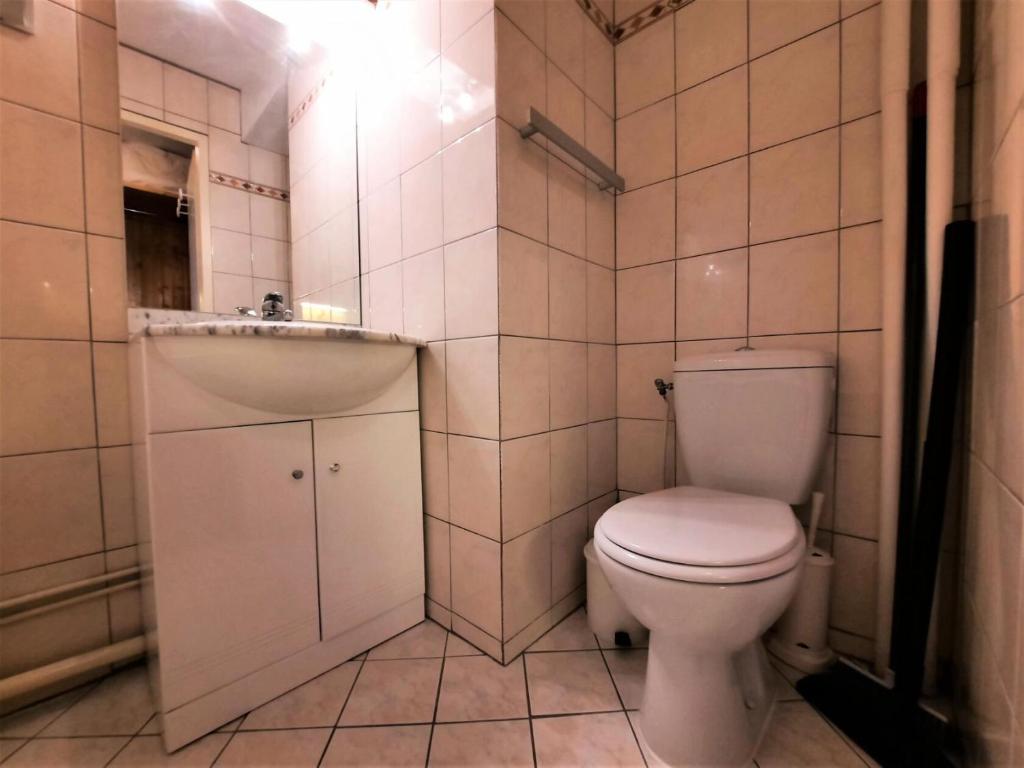 a small bathroom with a toilet and a sink at Résidence Chaviere - Studio pour 2 Personnes 034 in Les Menuires