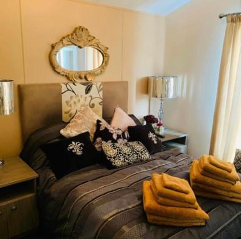 a bedroom with a bed with a mirror on the wall at Thorne Lodge - Seaview - 3 Bedroom in Whitstable
