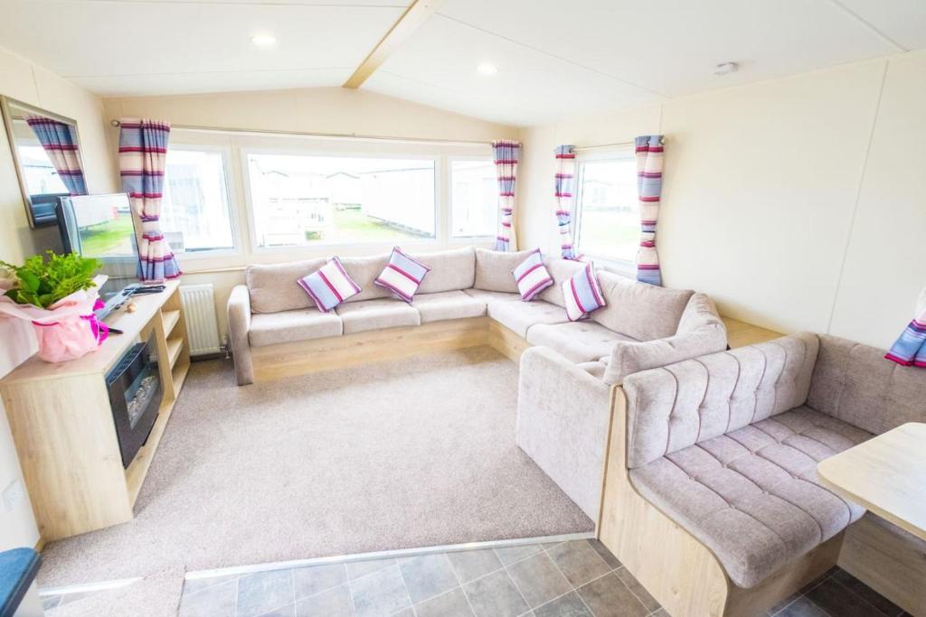 a living room with a couch and a tv at SP158 - Camber Sands Holiday Park - 3 Bedrooms - Second Toilet - Decking - Private Parking in Camber