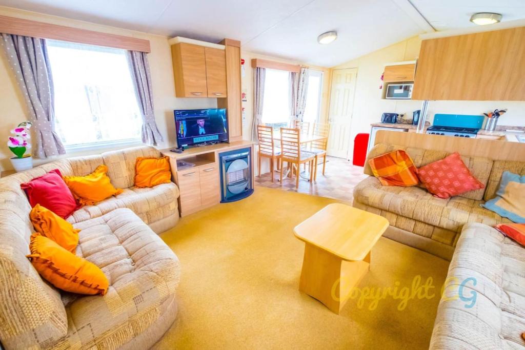 a living room with two couches and a kitchen at WW165 - Camber Sands Holiday Park - Sleeps 6 - 2 Bedrooms - 2 Bathrooms in Camber