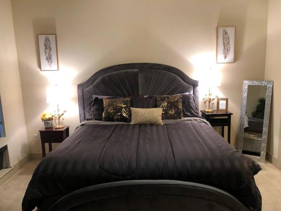 a bedroom with a large black bed with pillows at 2Bd/2Bth Hermann Park @ Med Ctr in Houston