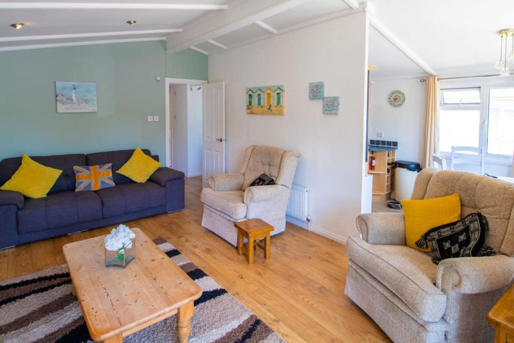 ein Wohnzimmer mit 2 Sofas und einem Tisch in der Unterkunft 11 The Oaks - Lodge - Coghurst Hall - Hastings in Westfield