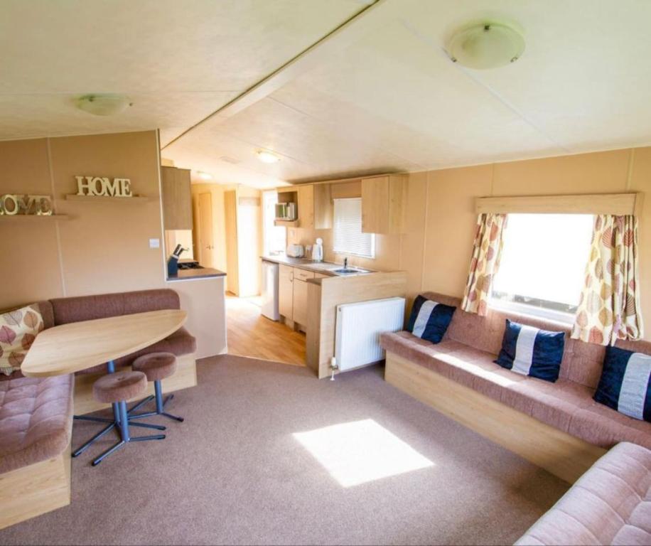 a small living room with a couch and a table at MP252 - Camber Sands Holiday Park - Central Spot in Camber