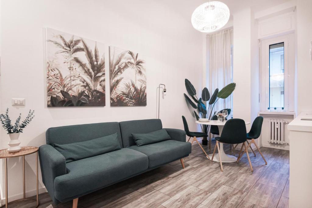 een woonkamer met een groene bank en een tafel bij Central wonderful flat Repubblica Central station in Milaan