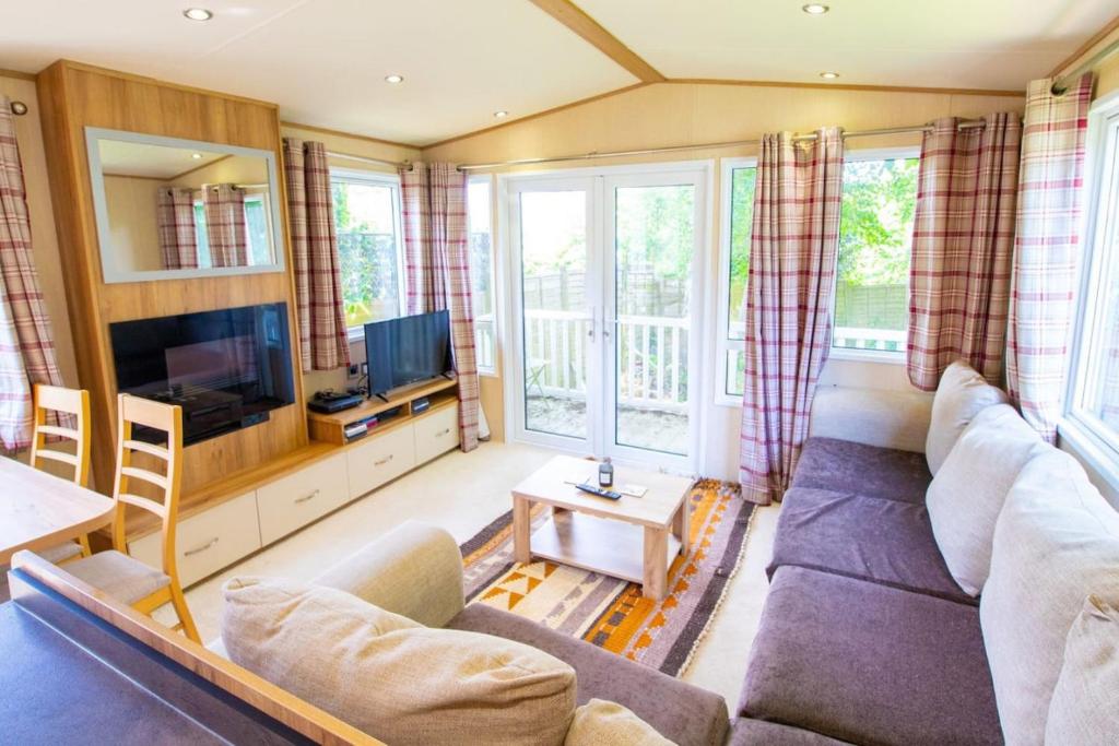 uma sala de estar com um sofá e uma televisão em Hazel Glen 3 - Beauport Park - Hastings em Hastings