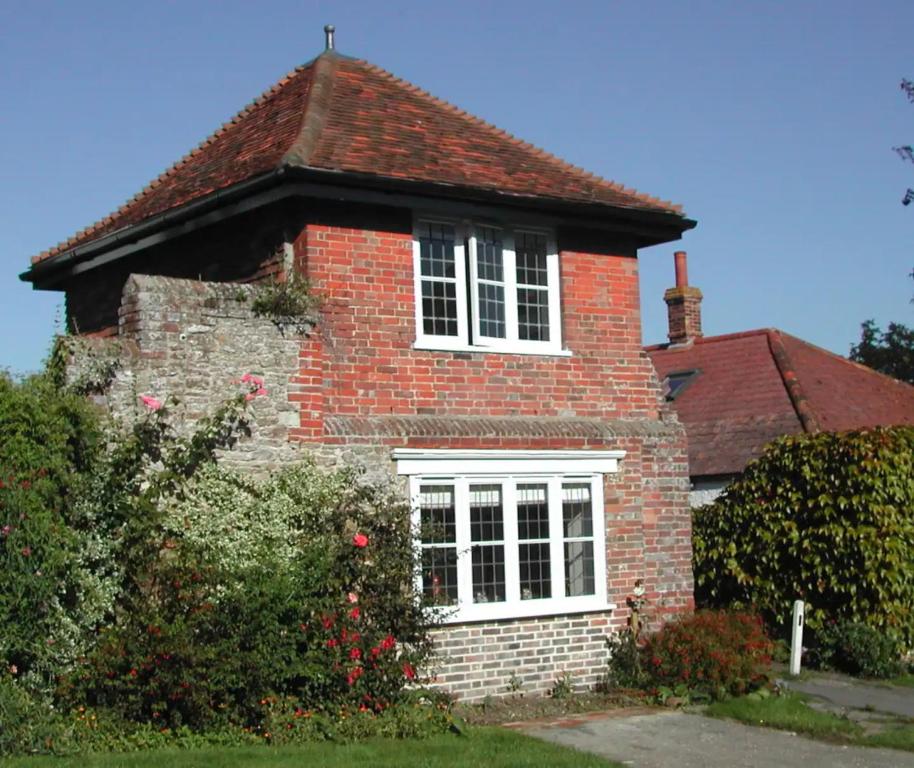 uma casa de tijolos vermelhos com uma janela branca em The Gazebo in Winchelsea em Winchelsea