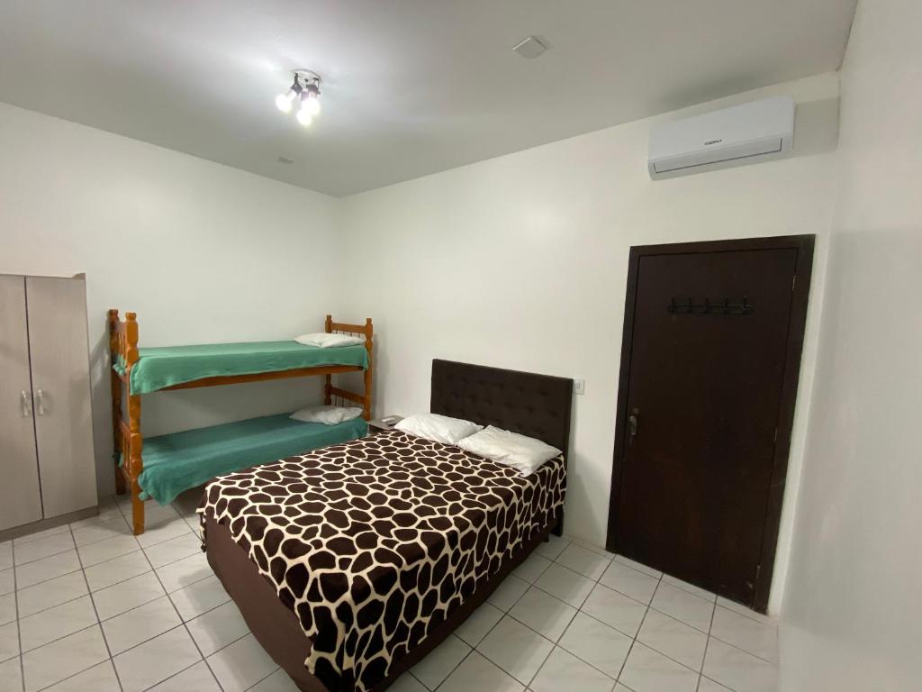 een slaapkamer met een bed en een kamer met een stapelbed bij Apartamento Principado in Torres