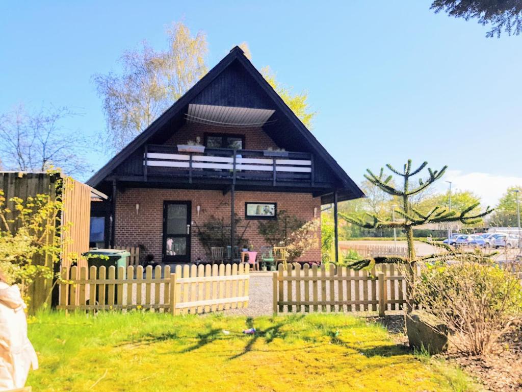een klein huis met een hek ervoor bij 5min walk to LEGO House - two bedrooms on Loft floor with Balcony * with garden in Billund