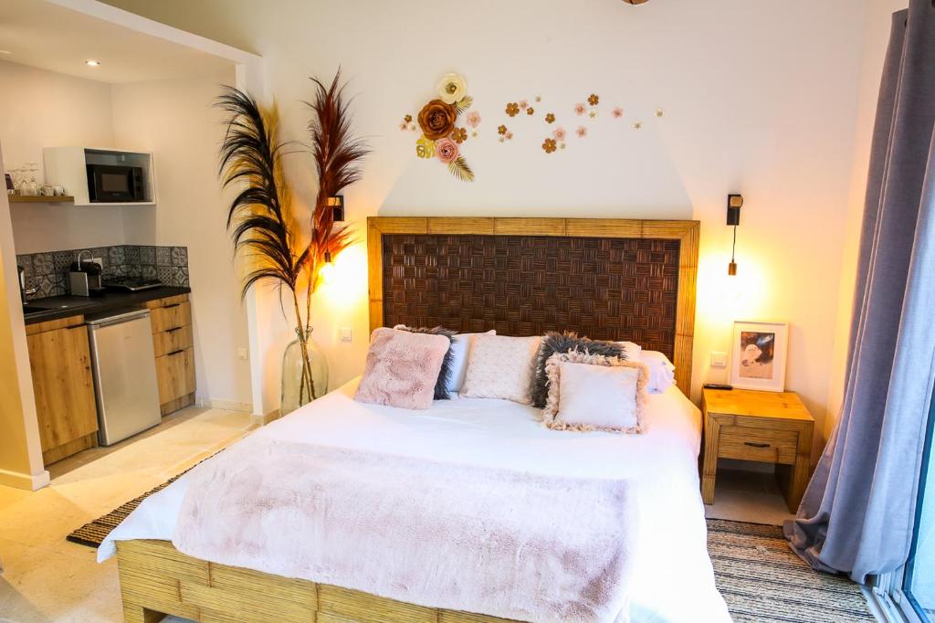 - une chambre avec un grand lit blanc et des oreillers roses dans l'établissement Séjour détente en Provence, à Ventabren