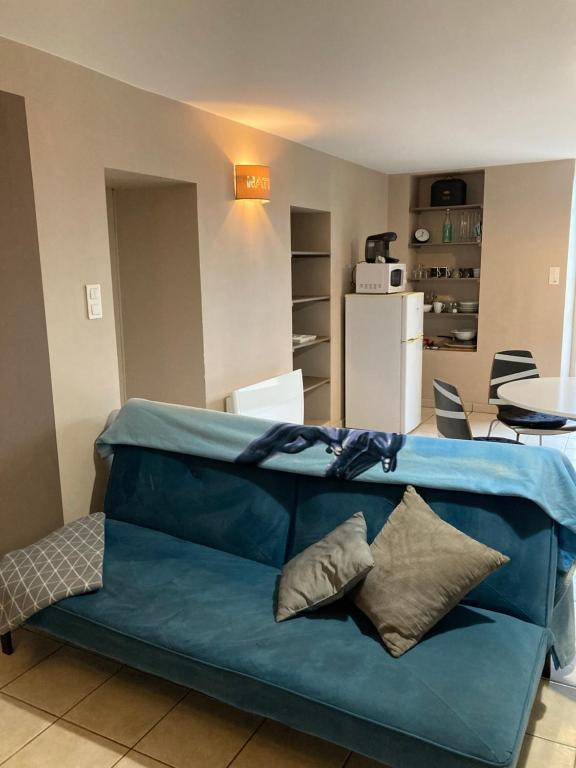 eine blaue Couch im Wohnzimmer in der Unterkunft Cholet 500m du cormier 15 min du puy du fou in Cholet