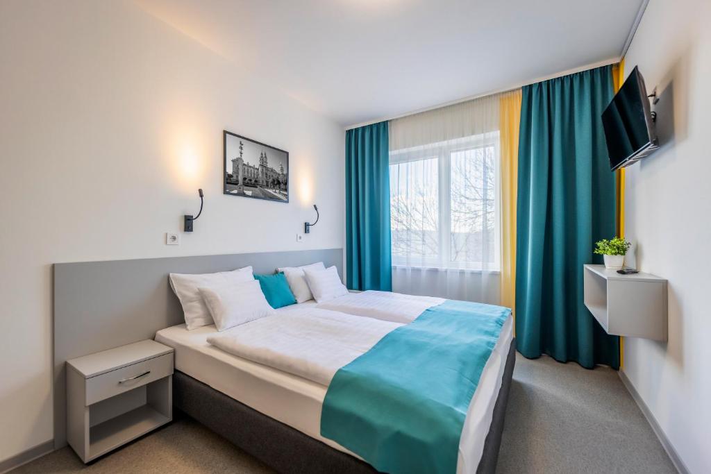 Un dormitorio con una cama grande y una ventana en Arrabona HotelRooms, en Győr