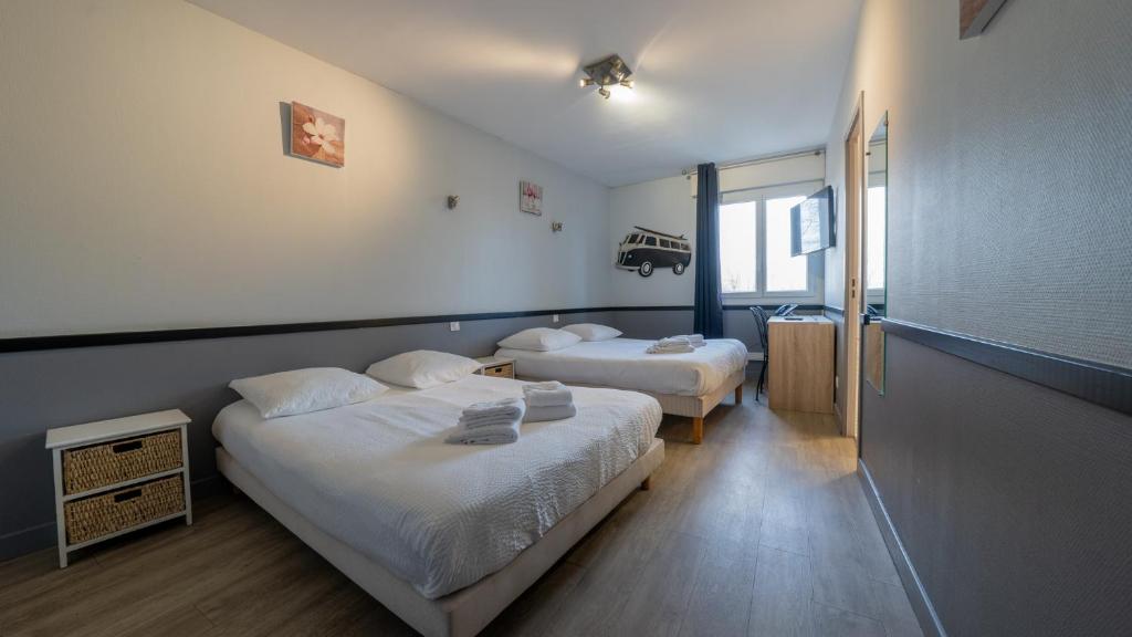 a hotel room with two beds and a window at Hôtel Des Docks in Digoin