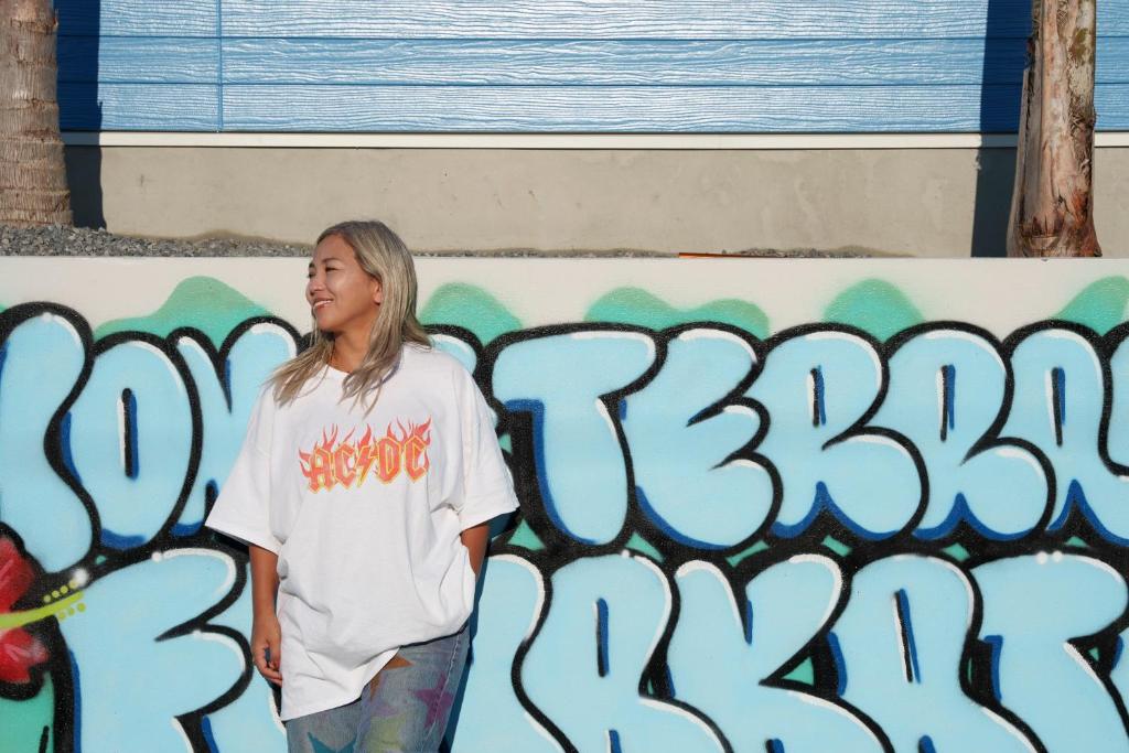 館山的住宿－HOMIE TERRACE Funakata，站在涂鸦墙前的妇女