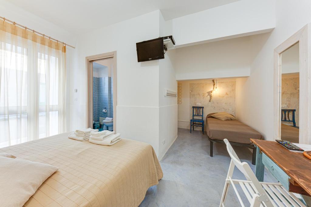 a hotel room with a bed and a desk and a bedroom at Il Pumo Bianco in Morciano di Leuca