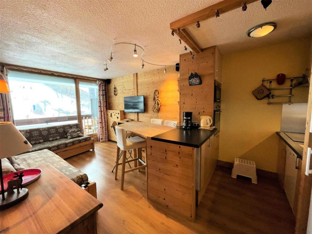 a kitchen with a desk and a table in a room at Résidence Peclet - 2 Pièces pour 4 Personnes 454 in Les Menuires