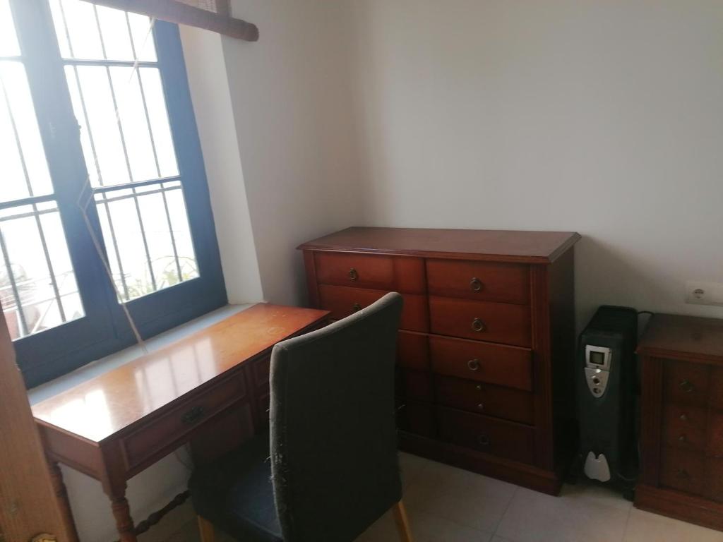 einen Schreibtisch und eine Kommode in einem Zimmer in der Unterkunft casa la salud in Málaga