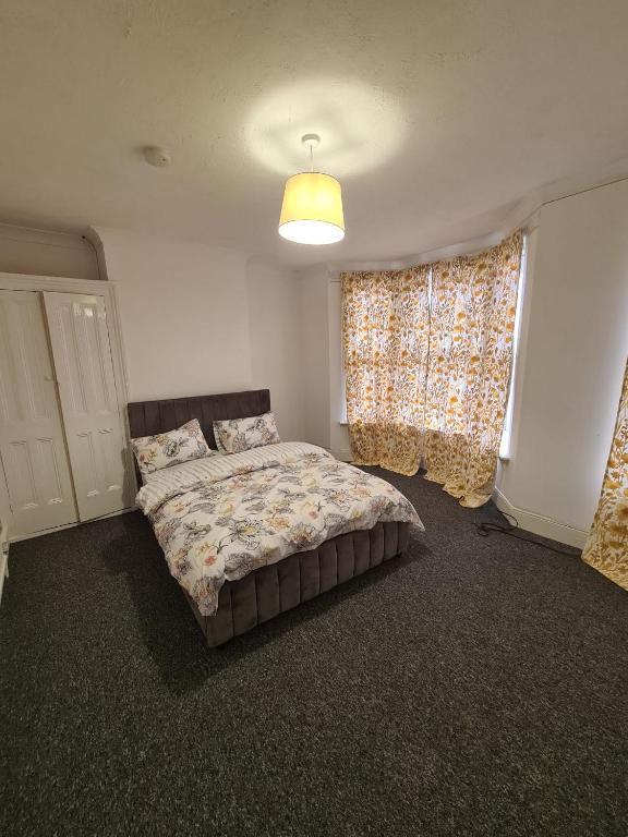 a bedroom with a bed and a window with curtains at Double Rooms with shared bathroom in Gillingham