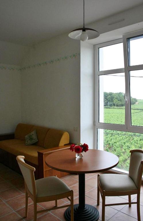 un salon avec une table et un canapé dans l'établissement Les Logis du Hallay, à La Haie-Fouassière