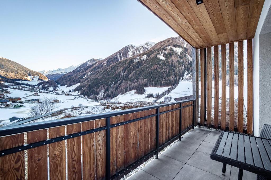 een balkon met een bank en met sneeuw bedekte bergen bij Stoana Apt 1-2 in San Giacomo