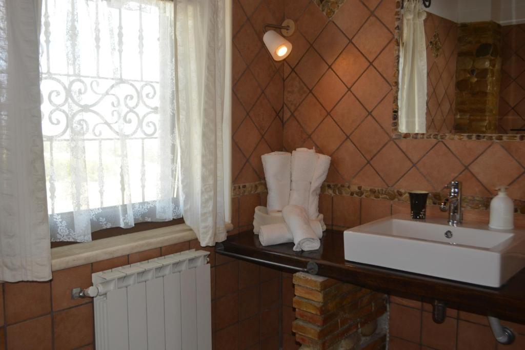 ein Bad mit einem Waschbecken, einem Spiegel und einem Fenster in der Unterkunft Villa Polercia in Cupello