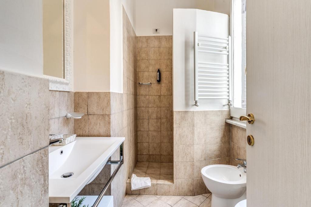a white bathroom with a sink and a toilet at Magenta Deluxe Cancello in Rome