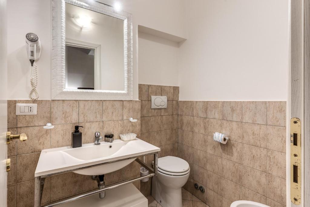 a bathroom with a sink and a toilet and a mirror at Magenta Deluxe Cancello in Rome