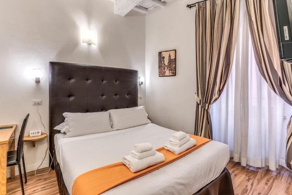 a bedroom with a bed with two towels on it at Magenta Deluxe Cancello in Rome