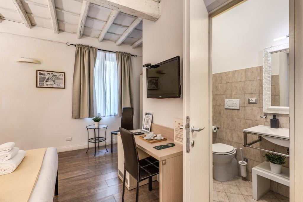 a room with a bed and a desk and a bathroom at Magenta Deluxe Cancello in Rome