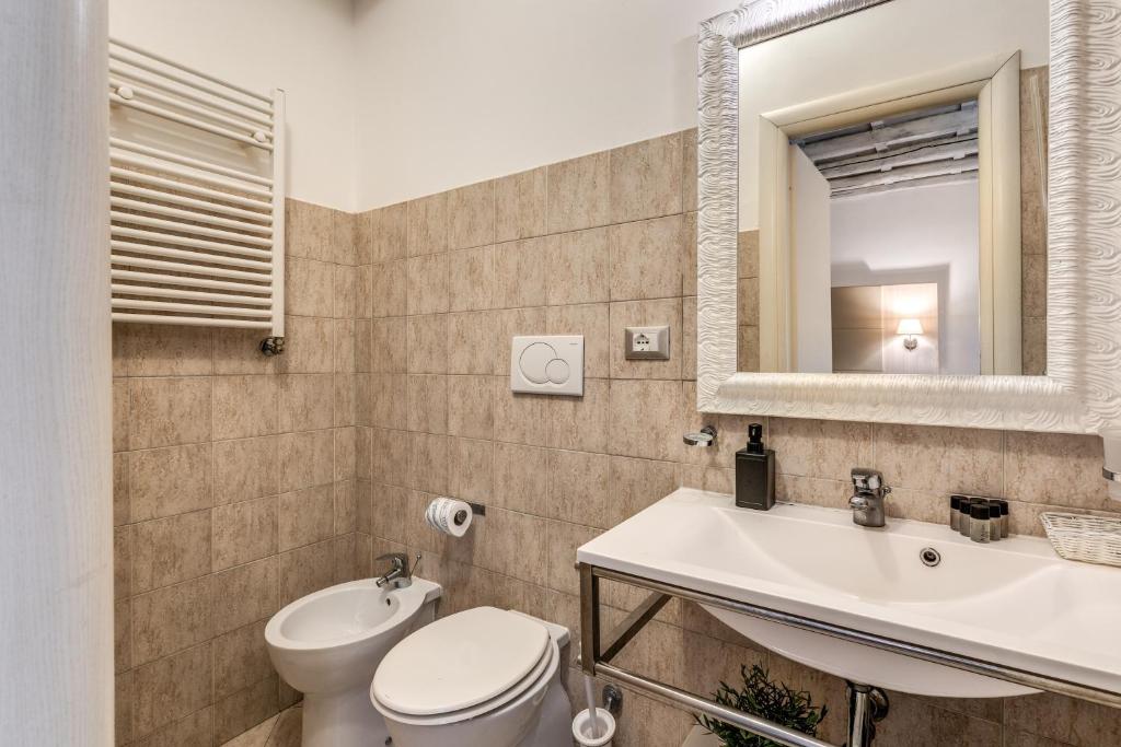 a bathroom with a toilet and a sink and a mirror at Magenta Deluxe Cancello in Rome