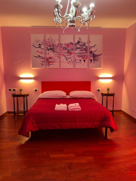 una camera da letto con un letto rosso con due asciugamani di B&B Villa Sabrina ad Arezzo