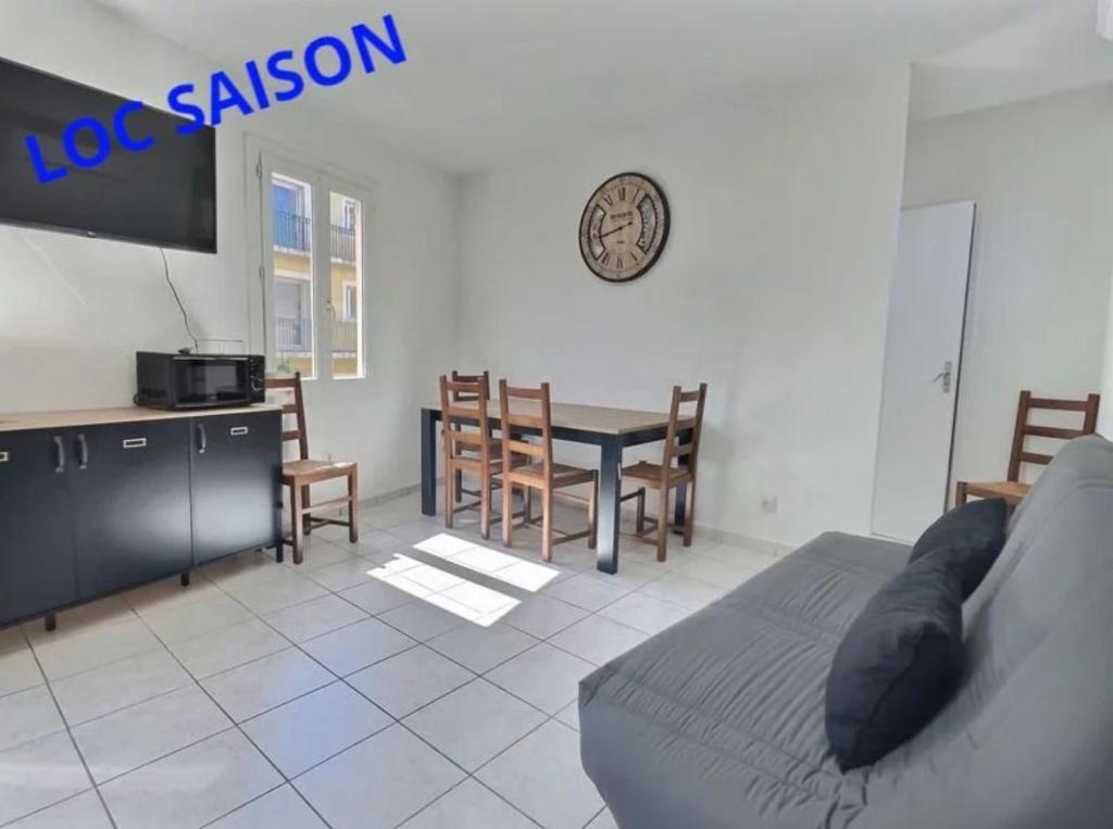 uma sala de estar com uma cama, uma mesa e cadeiras em Appartement plein centre 300m de la plage . em Valras-Plage