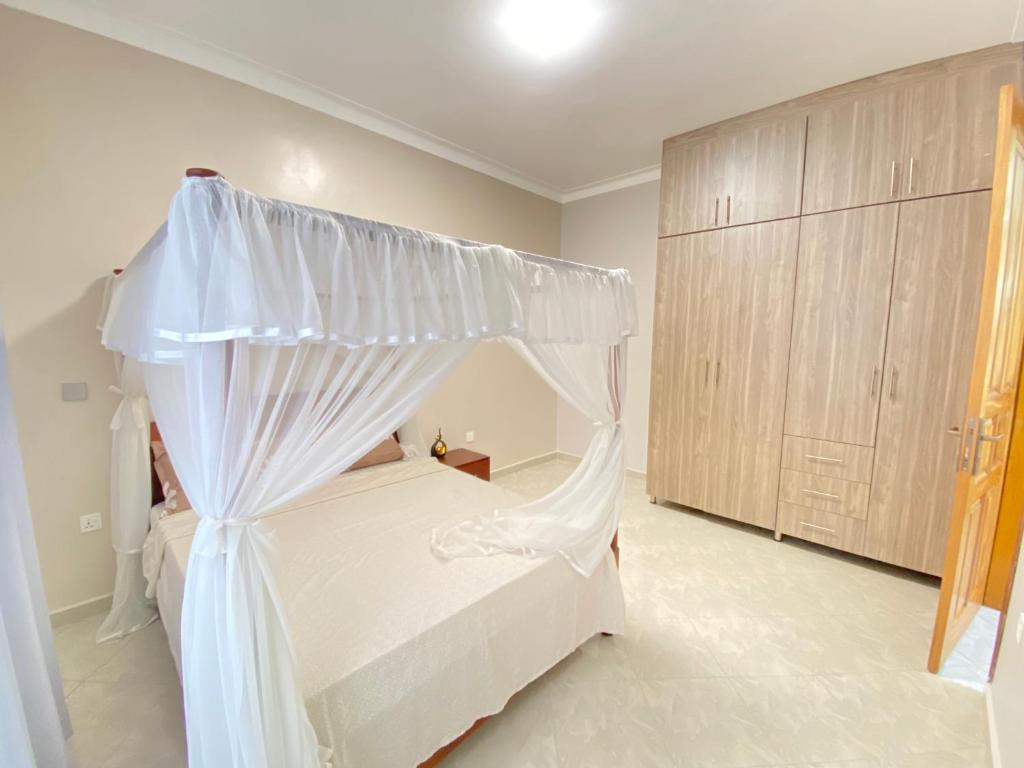 una camera con un letto bianco a baldacchino di Luxury Elegance Residence a Kampala