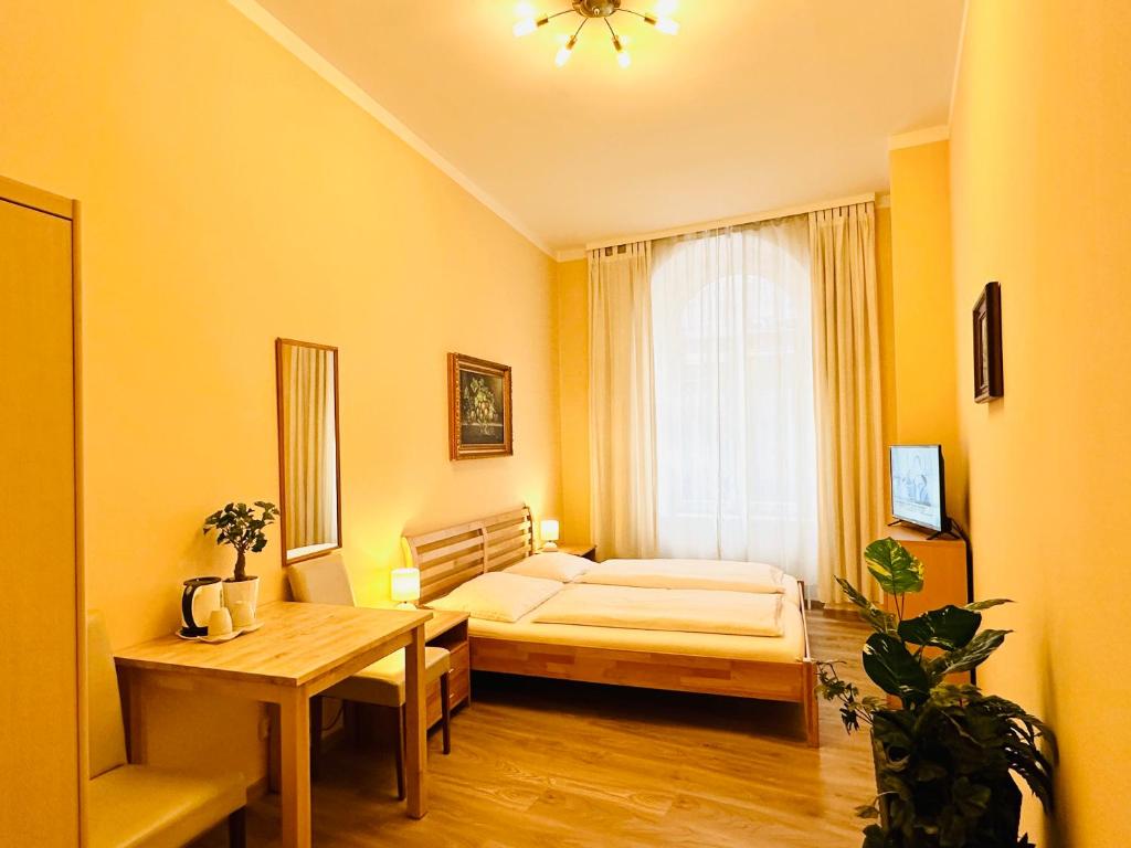 a bedroom with a bed and a table and a window at Pension Liechtenstein in Vienna