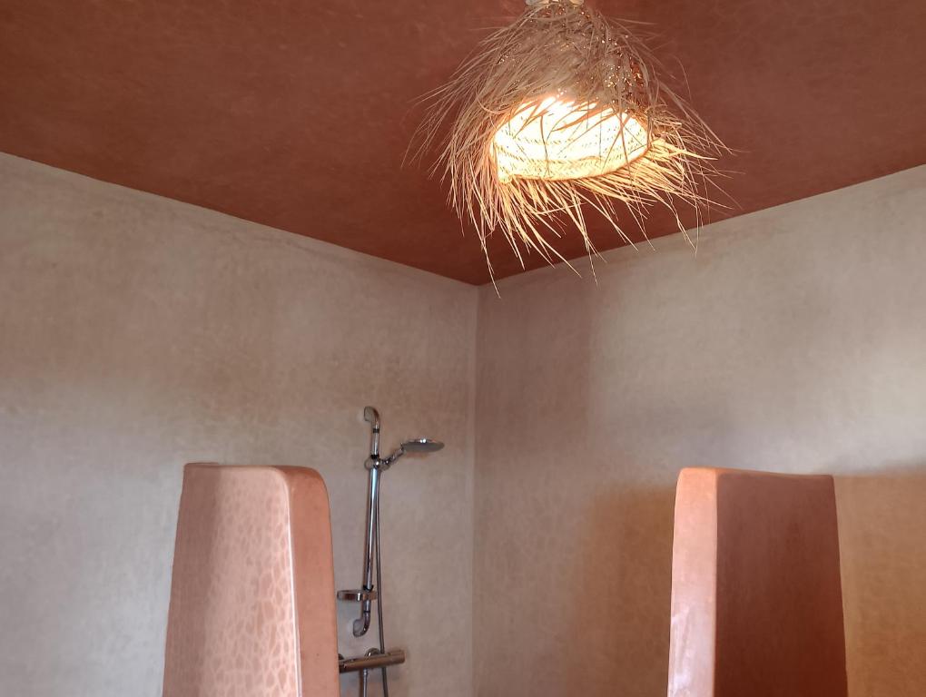 une salle de bain avec douche et lumière au plafond dans l'établissement Riad Ocean Beach Douira, à Agadir