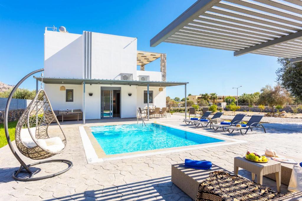 a villa with a swimming pool and a house at Villa Livis 1 in Kiotari