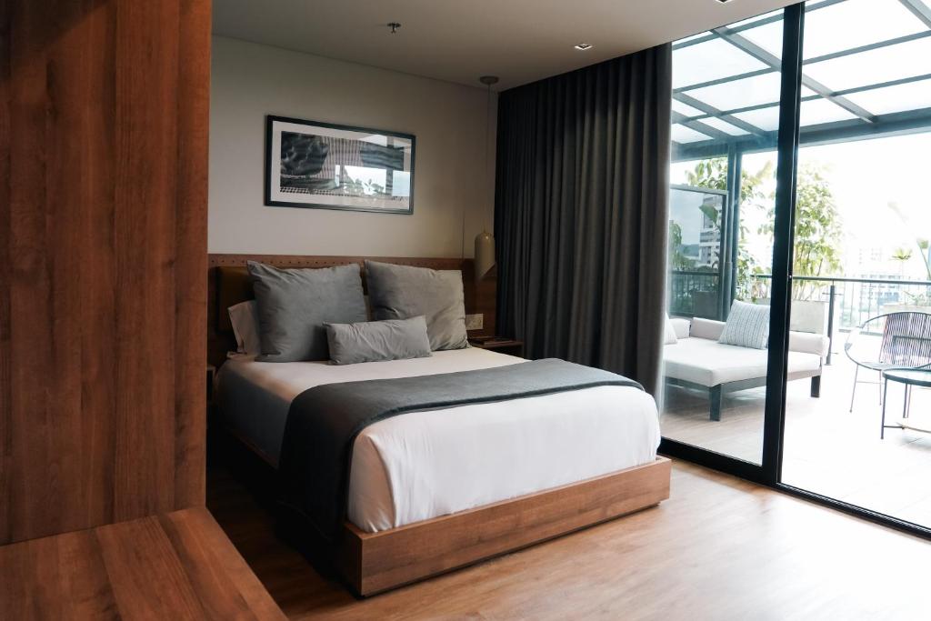 1 dormitorio con 1 cama y balcón en Hotel Sexto by Icono en Armenia